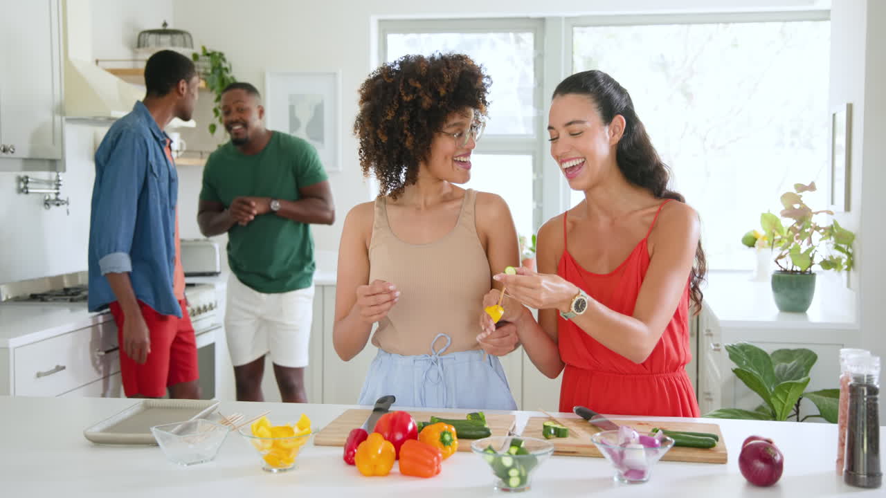 Diverse friends preparing colorful vegetables in kitchen, enjoying cooking together at home