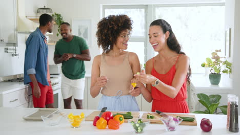 diverse friends preparing colorful vegetables in kitchen, enjoying cooking together at home