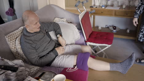 senior man recovering at home with injured leg