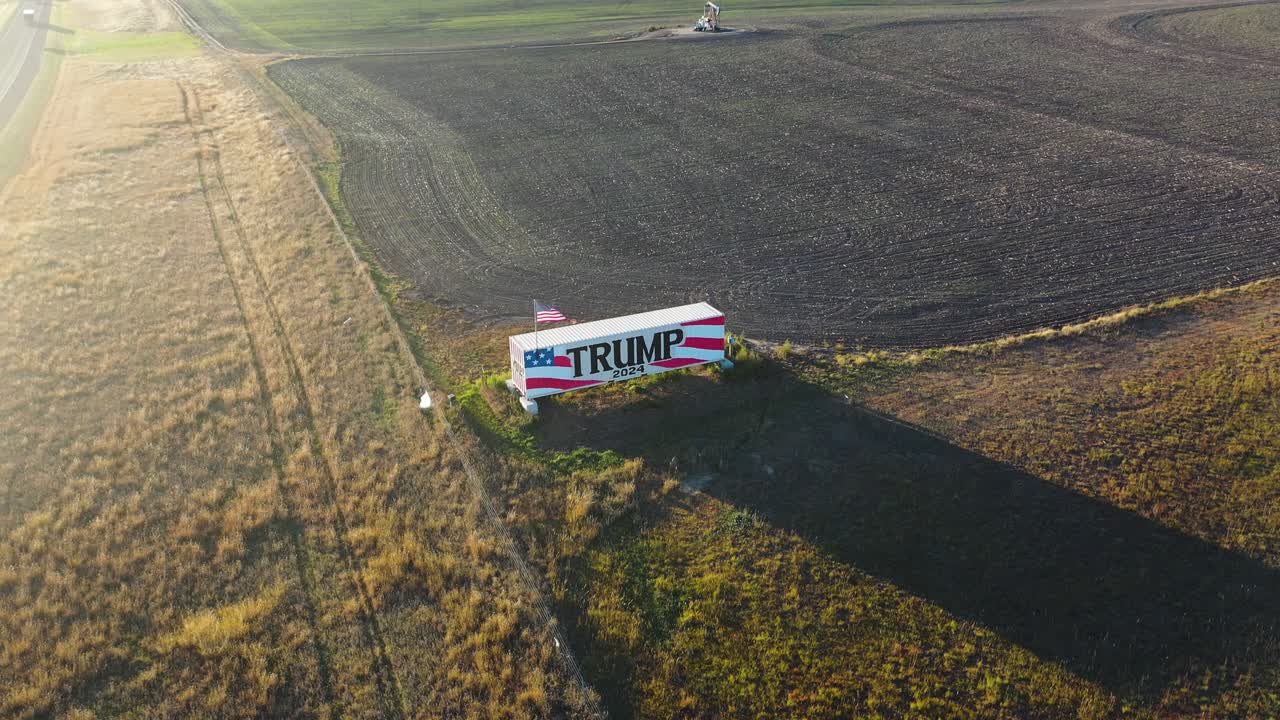 video de drones de 4k del propietario de tierras agrícolas partidario de donald trump con un letrero gigante de la campaña trump 2024 en el medio oeste o el sur alentando a la gente a votar por el presidente republicano