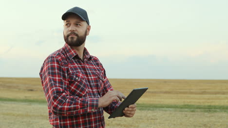 agricultor usando um tablet e observando suas colheitas