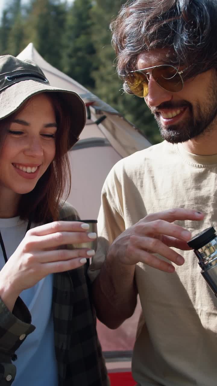 Couple enjoying a drink outdoors while camping