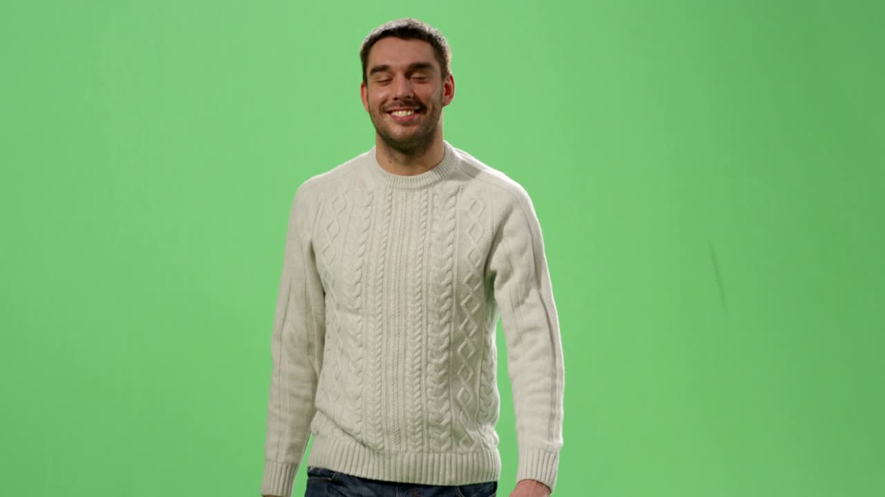 Ein lässiger kaukasischer Mann geht vor einem Mock-up-Greenscreen im Hintergrund.