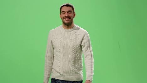 casual caucasian man is walking on a mock-up green screen in the background.