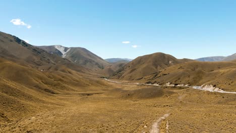 drone pan across large mountain valley with straight through road