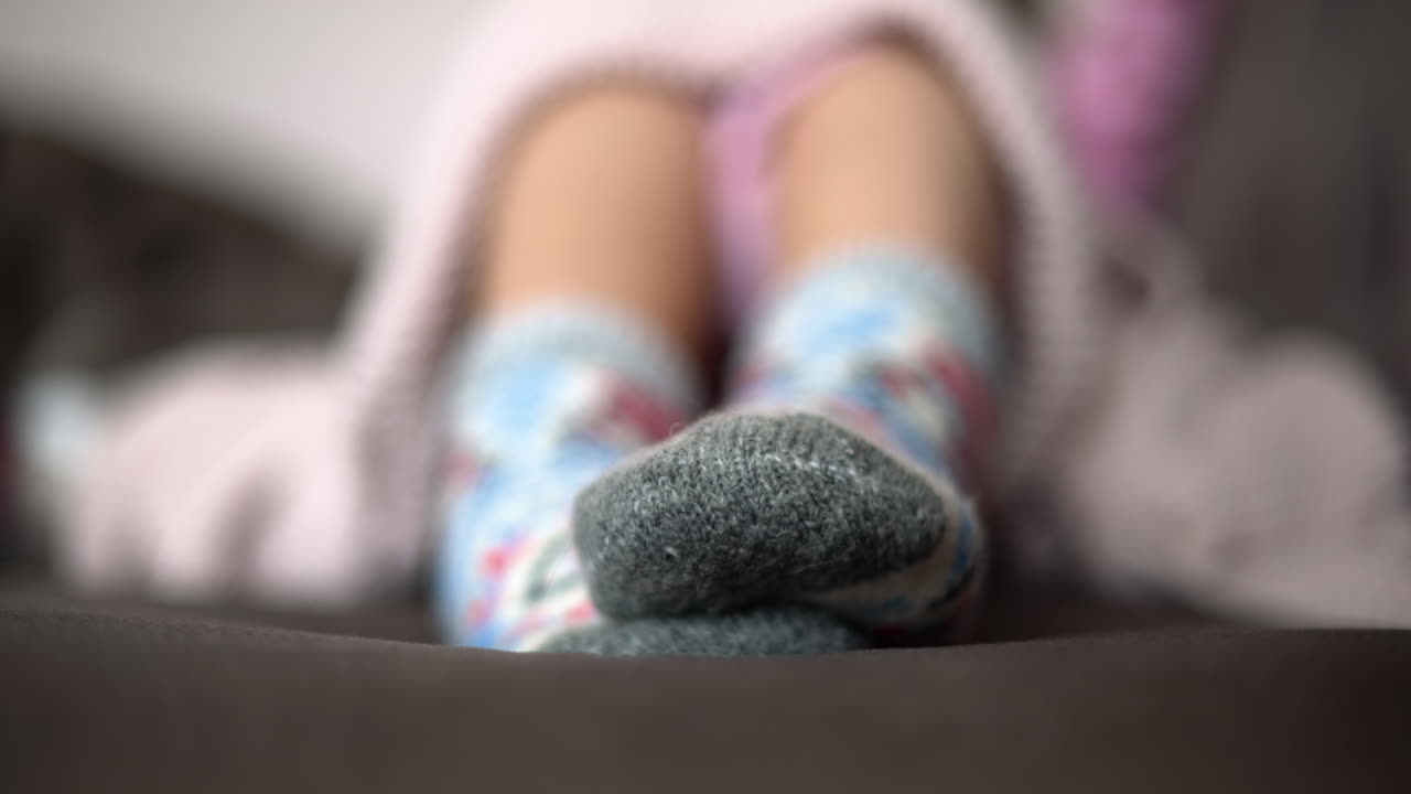 Primer plano de una mujer jugando con los pies mientras usa calcetines cómodos