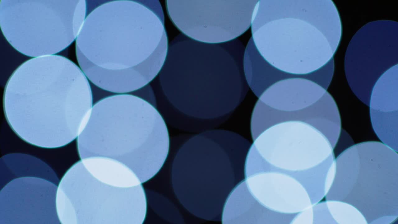 검은색 배경에 다채로운 박이는 보케가 있습니다.