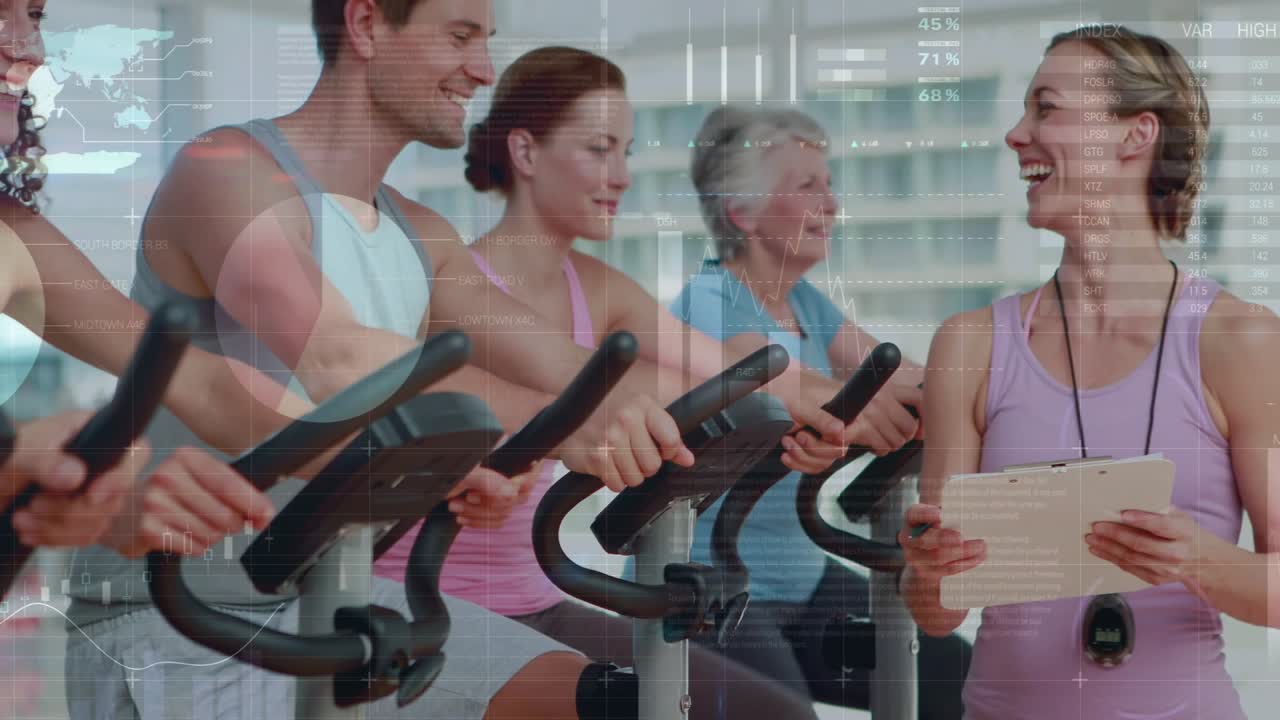 Instructor checking tablet, cueing gym riders pedaling and shifting grip while HUD tracking output