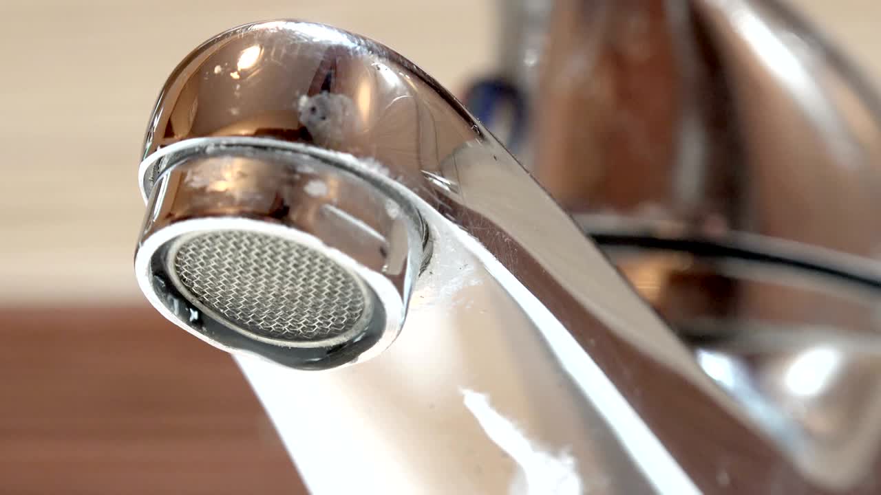 Acqua del rubinetto che gocciola nel lavandino, sfondo in loop