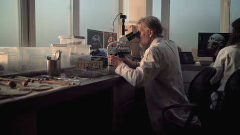 científico examinando un espécimen bajo un microscopio en un laboratorio