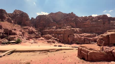 Petra-valley-in-Wadi-Musa,-Jordan-with-The-Treasury-in-the-middle-of-a-rocky-and-mountainous-landscape,-an-UNESCO-heritage-site,-ancient-Nabatean-Kingdom-4K-Establish-Shot