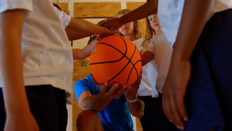 entrenador de baloncesto y escolares formando una pila de manos en la cancha de baloncesto 4k