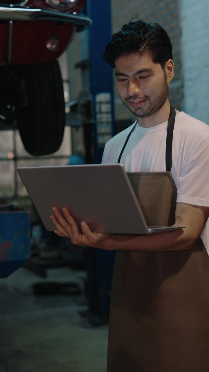 Mechanic working on a laptop in a garage
