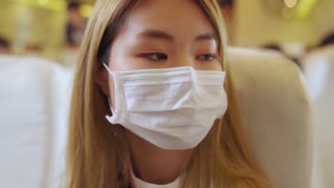 traveler wearing face mask while traveling on commercial airplane .