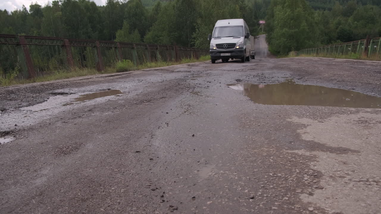 구과 밴이 있는 손상된 시골 도로