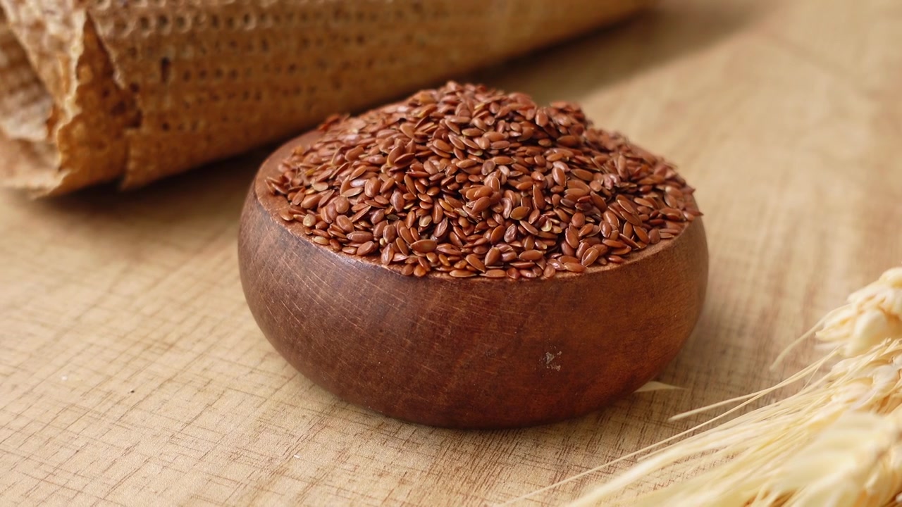 Wooden Bowl Filled With Flax Seeds on a Rustic Wooden Table