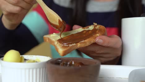 spreading popular spanish recipe dulce de leche onto toast and butter