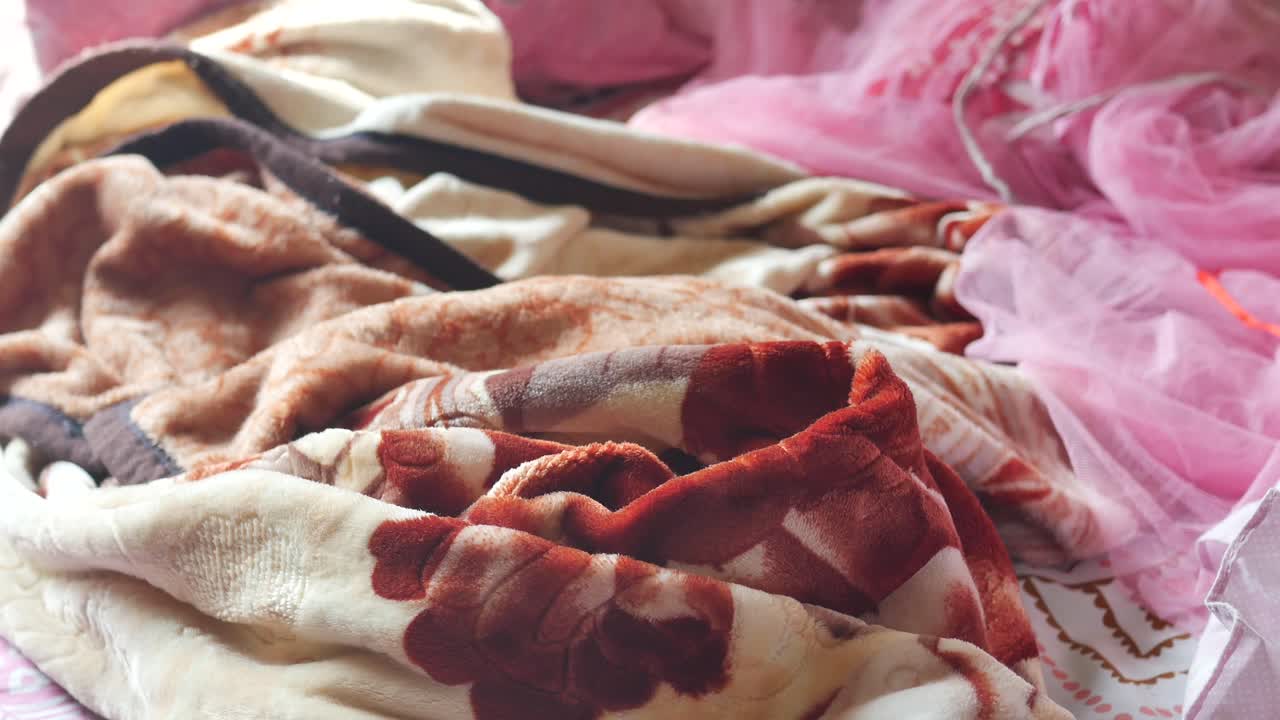 беспорядочная кровать с розовыми и коричневыми одеялами