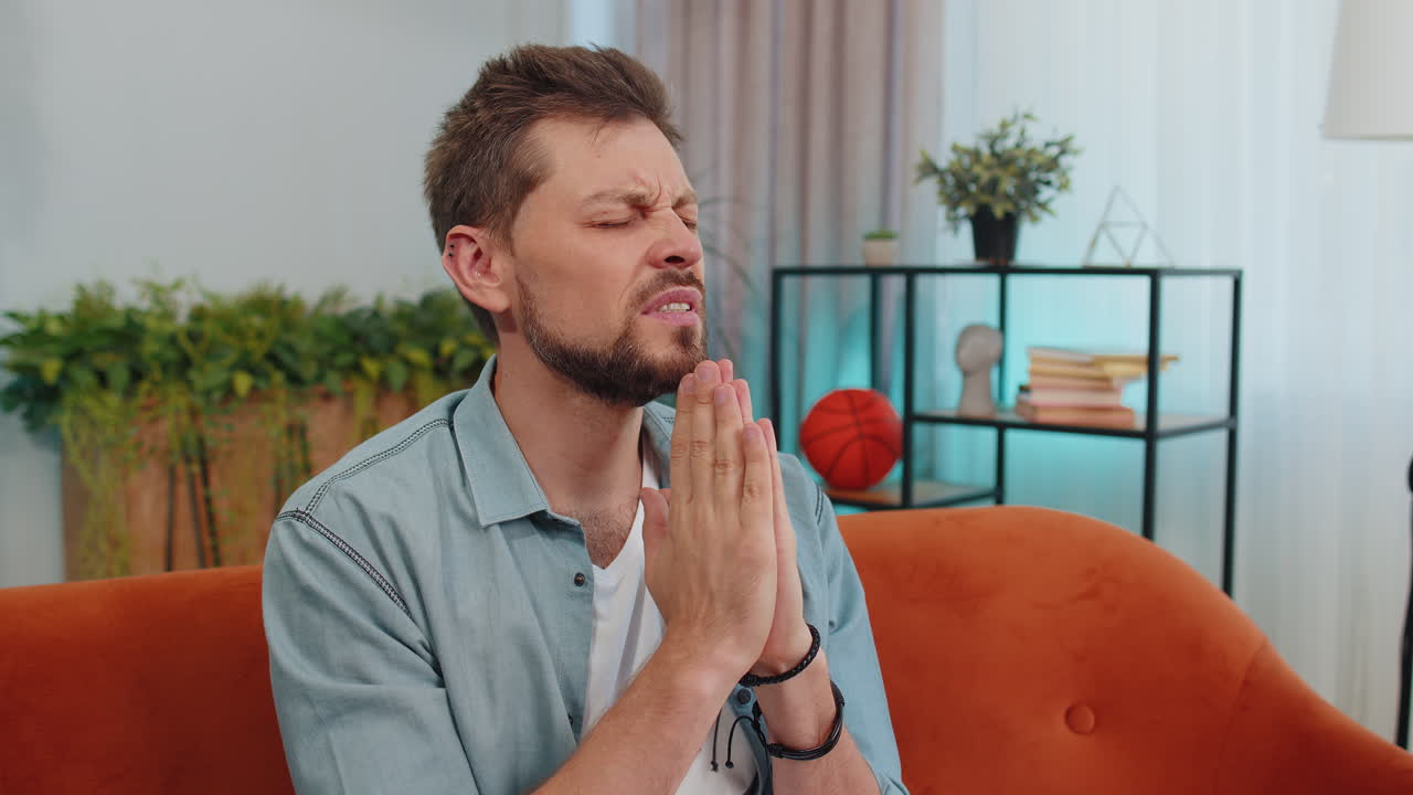 한 젊은이가 팔을 고 진심으로 기도하고, 하나님께 도움을 구하고, 사과하고, 소원을 하고 있다.