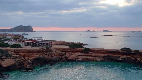 Schöne-Luftaufnahme-Von-Oben,-Flug,-Yoga,-Mädchen,-Punkte,-Sonnenuntergang,-Klippe,-Strand,-Insel,-Ibiza,-Spanien