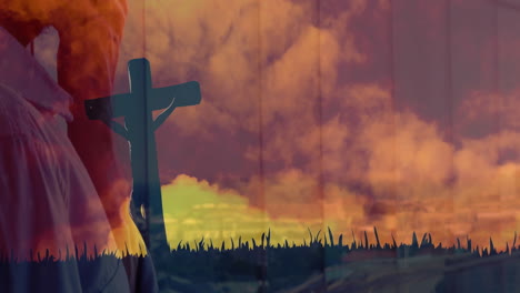 cross silhouetted against vibrant sunset sky with clouds and grass in animation