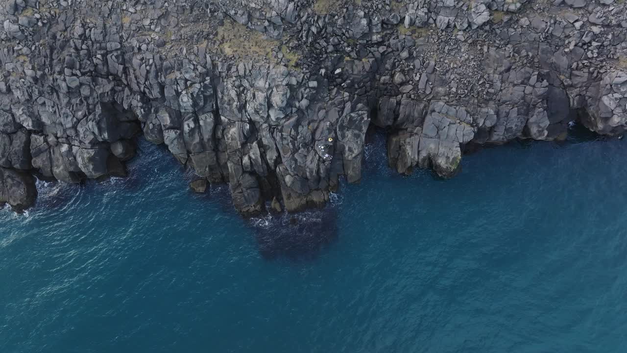 Vista aerea dall'alto di calme acque islandesi, rocce basaltiche sulla costa - Marea atlantica