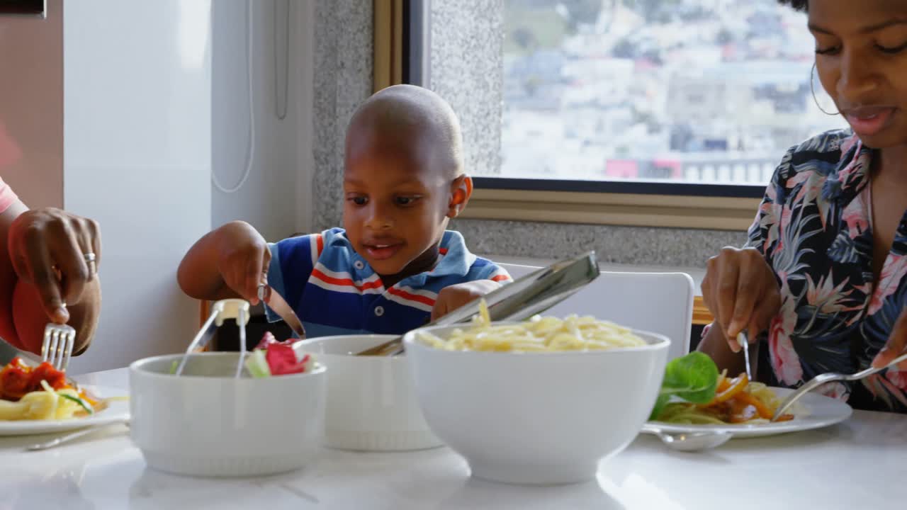 Family having food at dining table in a comfortable home 4k
