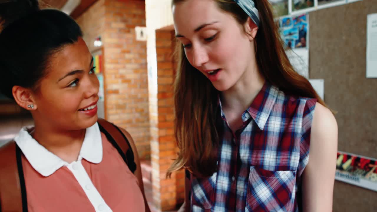 Schoolgirls reading in corridor