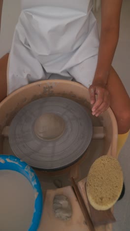 hands shaping clay on a pottery wheel in a pottery workshop