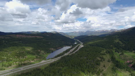 Vista-Aérea-De-Drones-De-Alta-Definición-De-La-Autopista-Interestatal-Estadounidense-I-70-Rodeada-De-Un-Paisaje-De-Bosque-Verde-Durante-El-Hermoso-Día-Nublado-De-La-Temporada-De-Verano