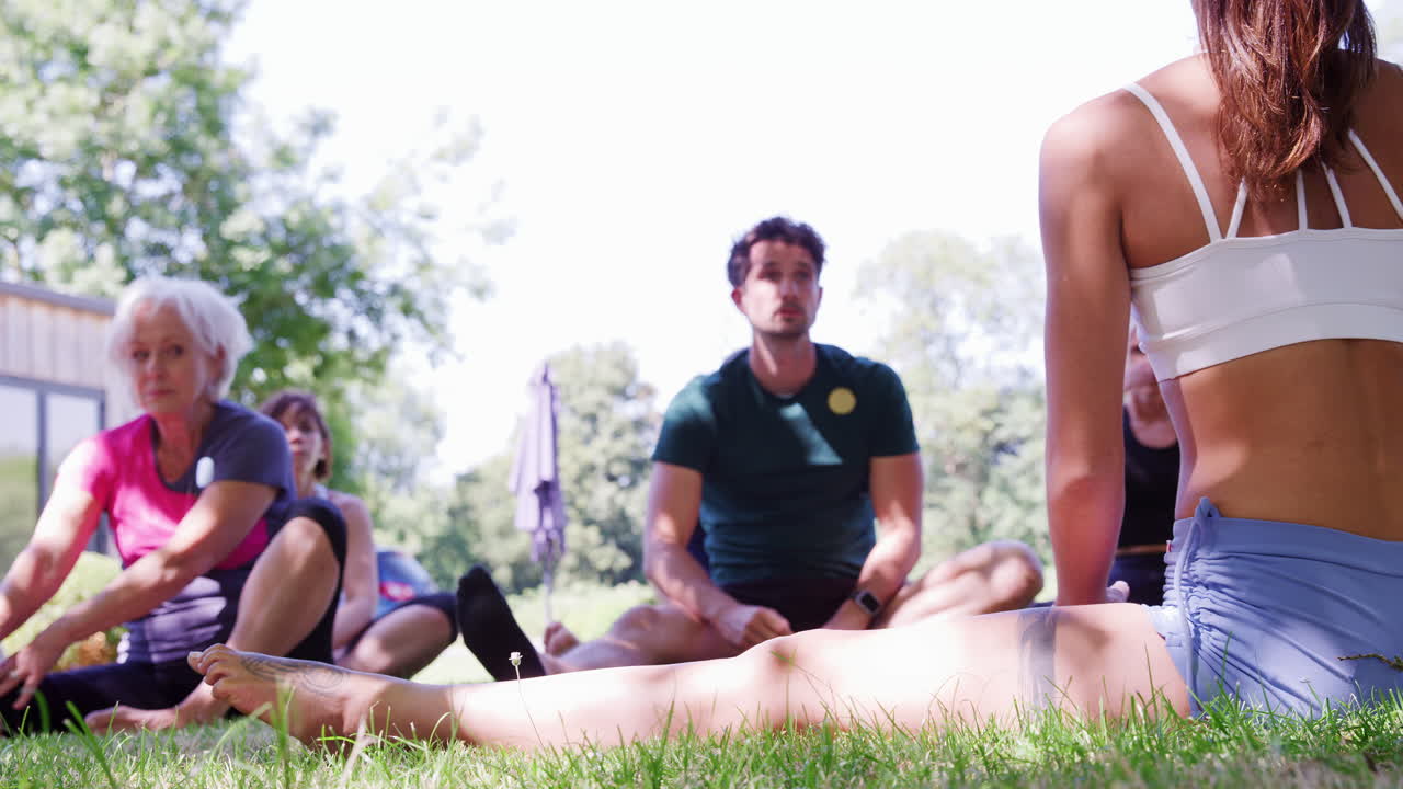 야외 요가 수업을 지도하는 여성 강사