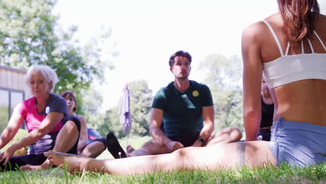 instructora que dirige una clase de yoga al aire libre