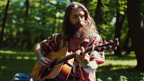 man playing acoustic guitar in a park