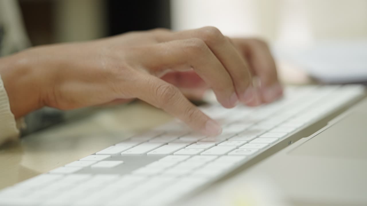 las manos de la mujer de negocios escribiendo en el teclado de la computadora portátil para buscar información, informe de investigación de marketing en el escritorio de la oficina