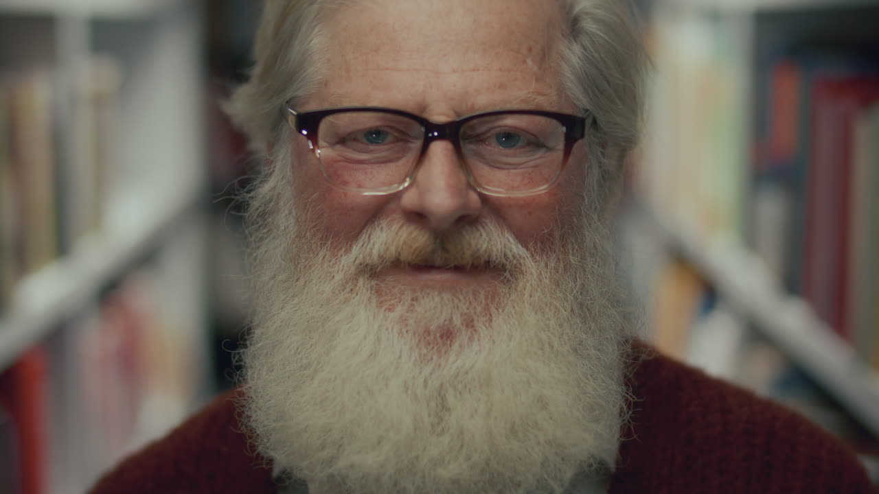 retrato de un anciano con barba blanca y gafas en la biblioteca