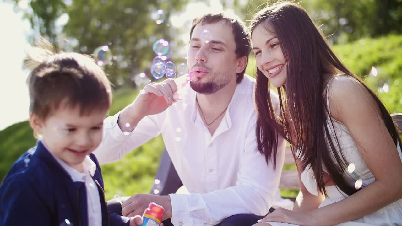 Happy Family Playing with Bubbles in the Park