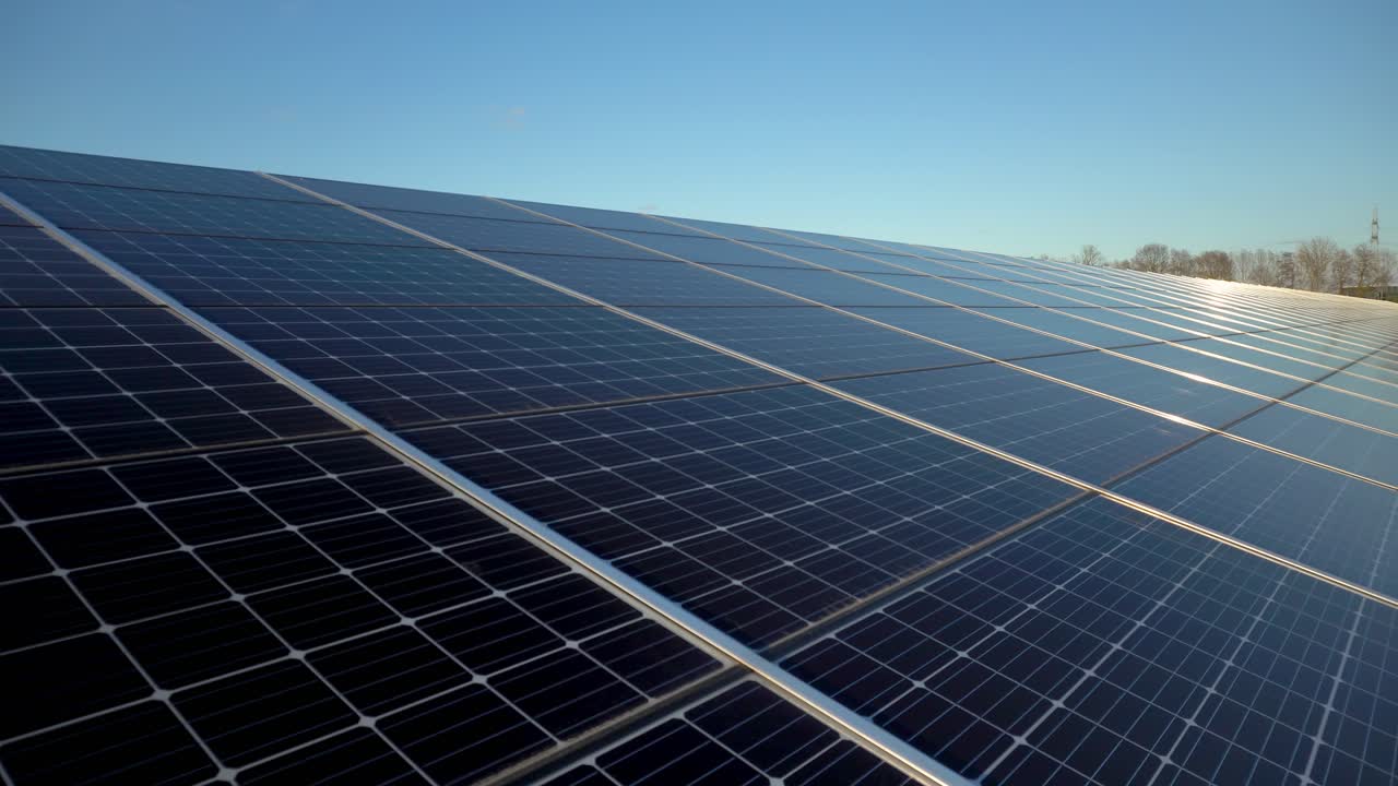 Large scale solar farm solar panels generating electricity on sunny day, pan