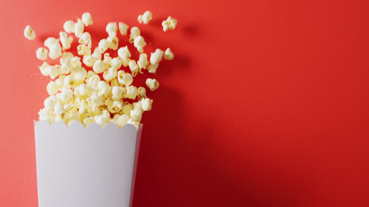 Video of close up of popcorn on red background