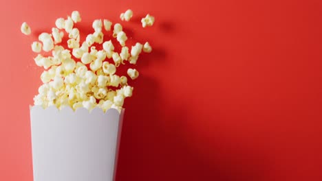 Video-of-close-up-of-popcorn-on-red-background