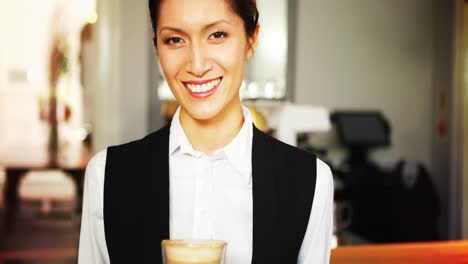 retrato de una camarera sonriente sosteniendo una bandeja de vaso de café