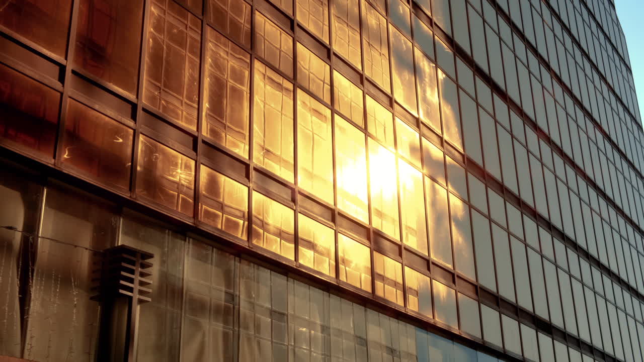 유리와 강철로 된 금빛 벽은 태양 광선에 반사되어