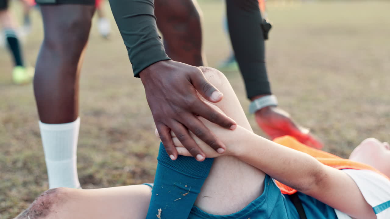 Soccer player injured, getting help from coach