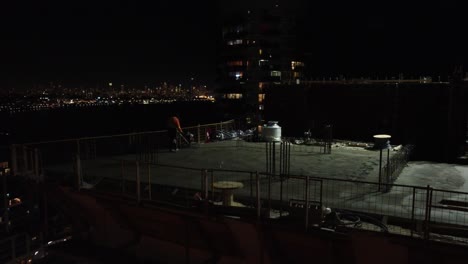 Aerial-footage-of-a-worker-building-a-skyscraper-at-night-with-the-help-of-a-crane,-capturing-the-beauty-of-urban-construction