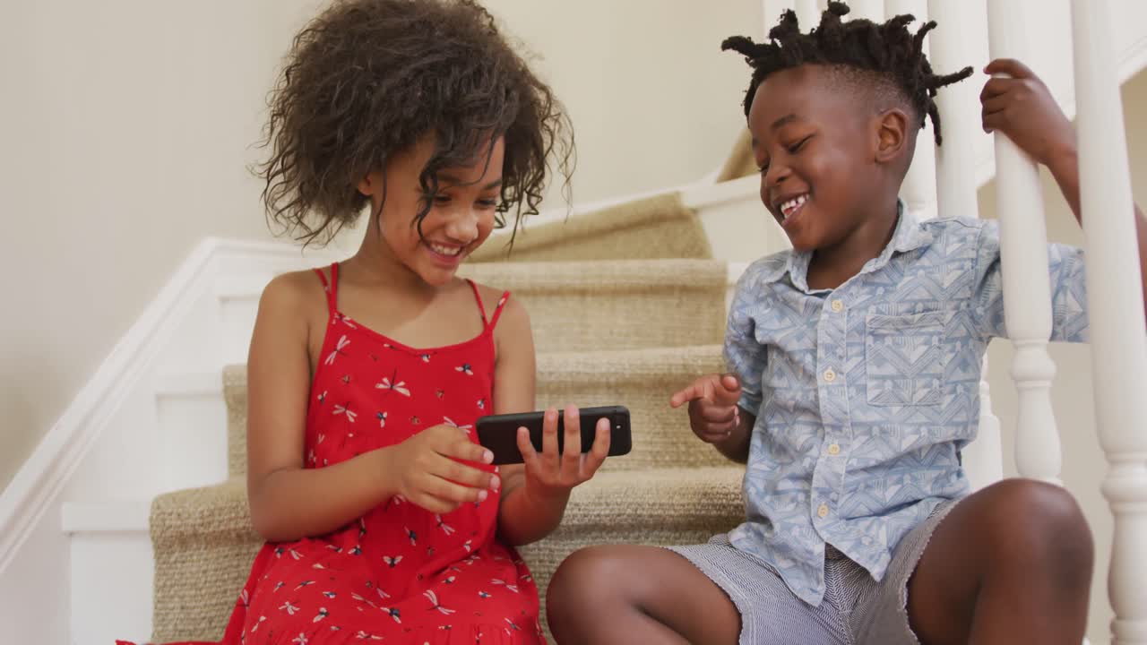 Young boy and girl using smartphone at home