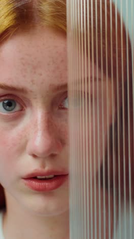 woman with red hair and glass panel