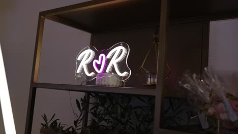 illuminated r and r neon sign with heart on decorated wedding shelf