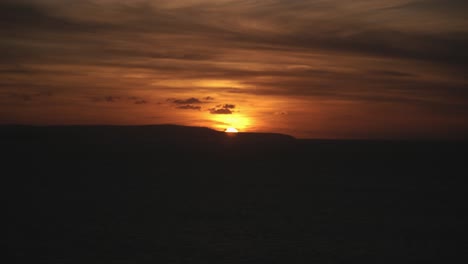 beautiful golden sunset just hiding behind the land on the horizon