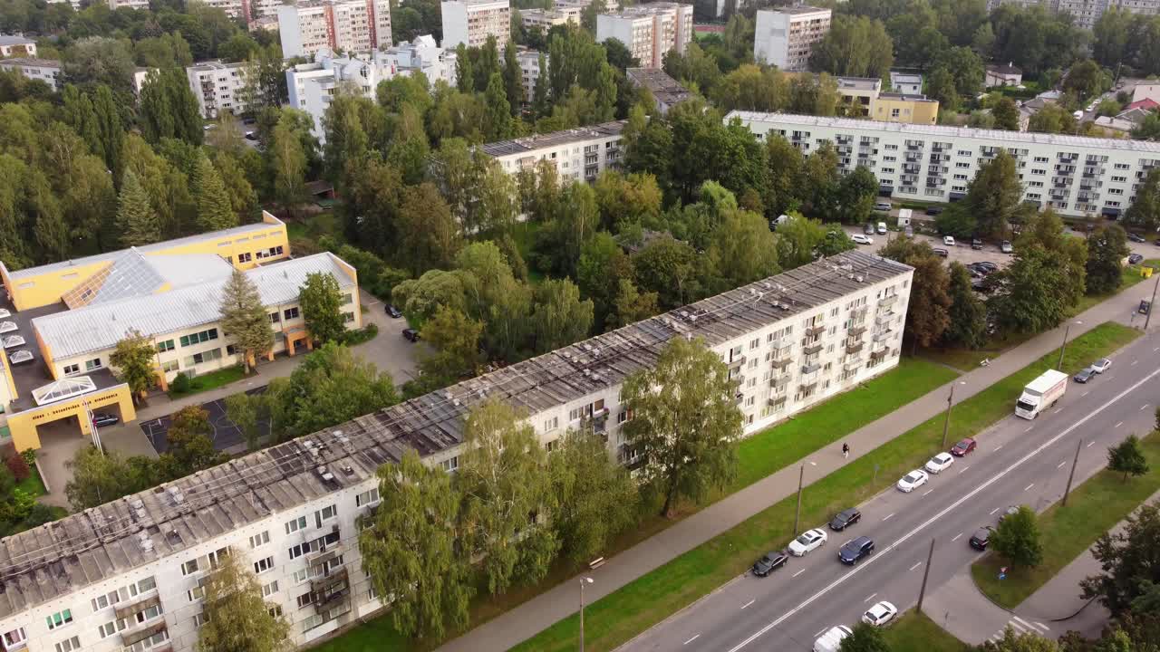 Aerial view of residential block buildings and green spaces along a main road in Purvciems, Riga