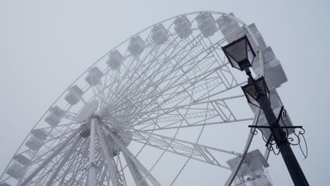 Rueda-De-Ferris-Intermitente-Y-Farola-Victoriana-En-Un-Día-De-Invierno-Brumoso