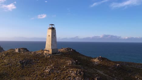 Solitary-lighthouse-on-a-rugged-hill-under-blue-skies-in-Venezuela,-conveying-a-sense-of-remote-travel